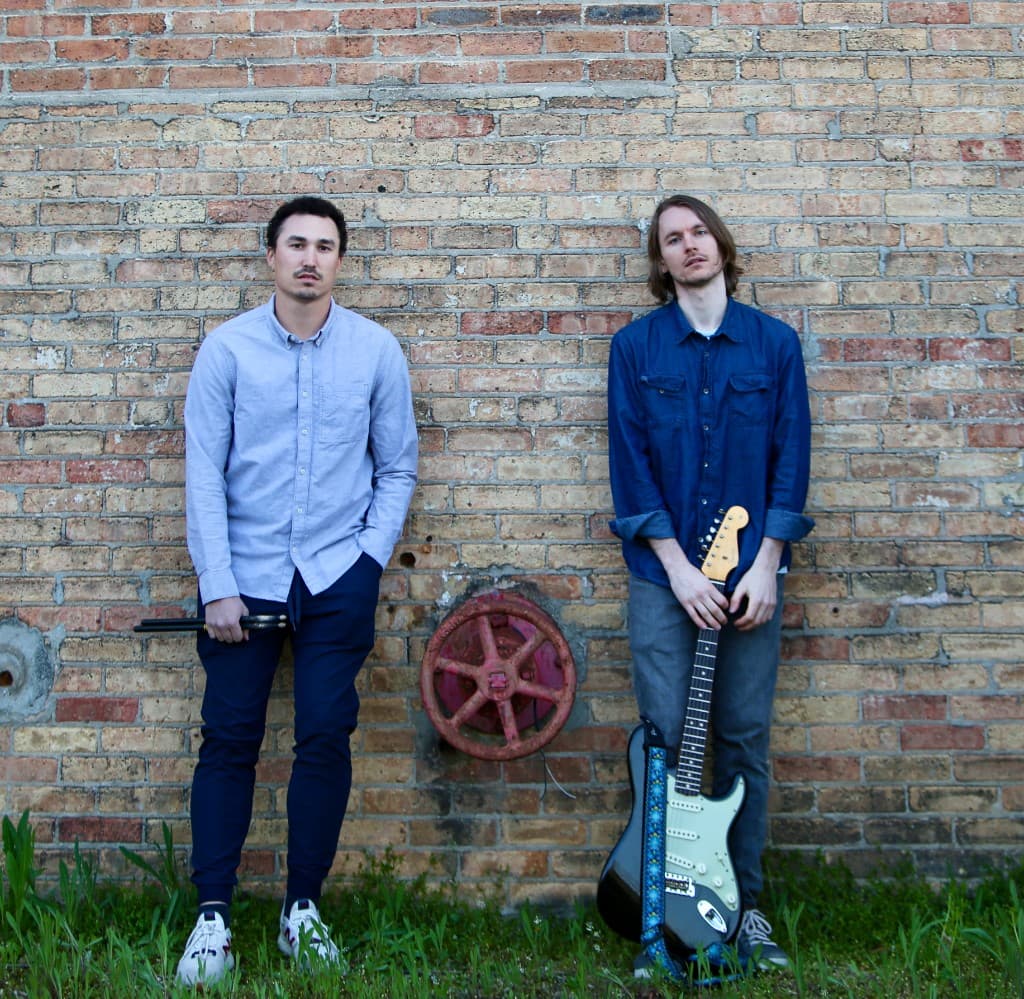 FORM standing in front of a brick wall