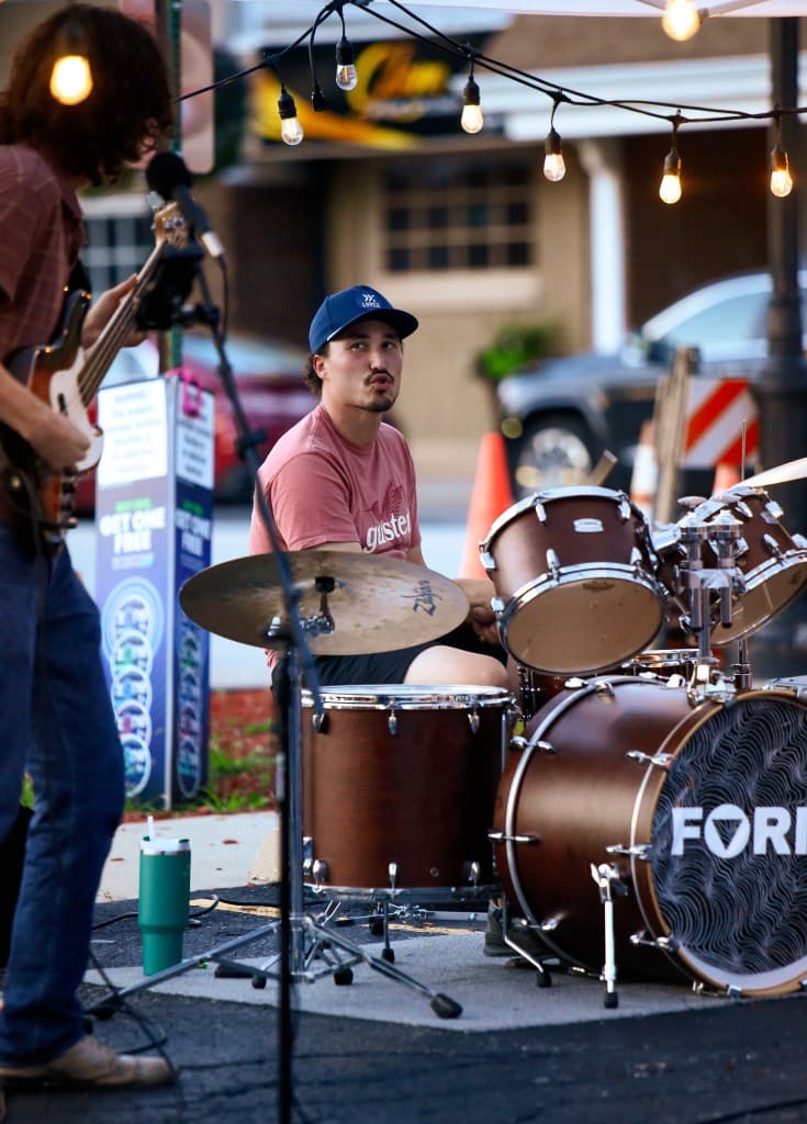 FORM drummer performing under string lights